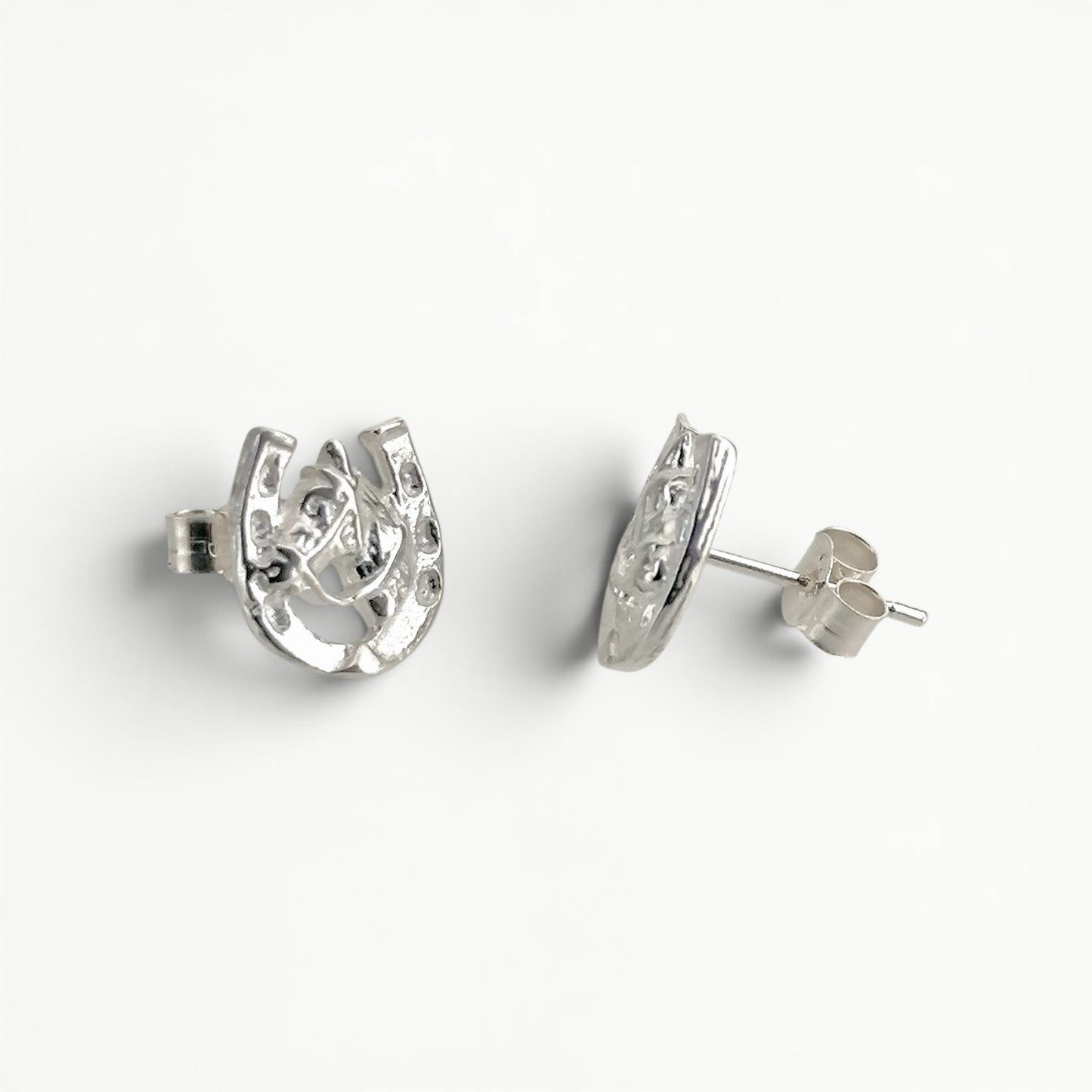 Sterling silver horseshoe with horse head studs earrings side view.