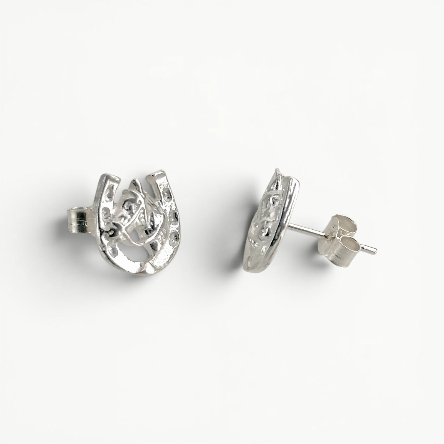 Sterling silver horseshoe with horse head studs earrings side view. 