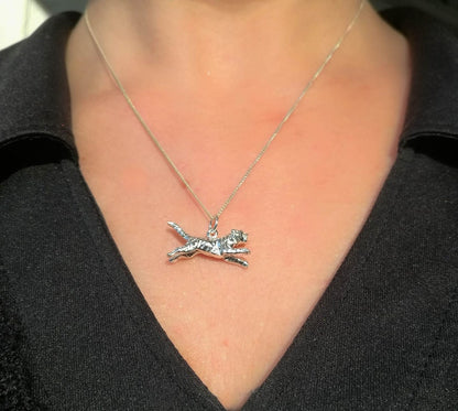 Sterling silver leaping tiger pendant worn on female model.